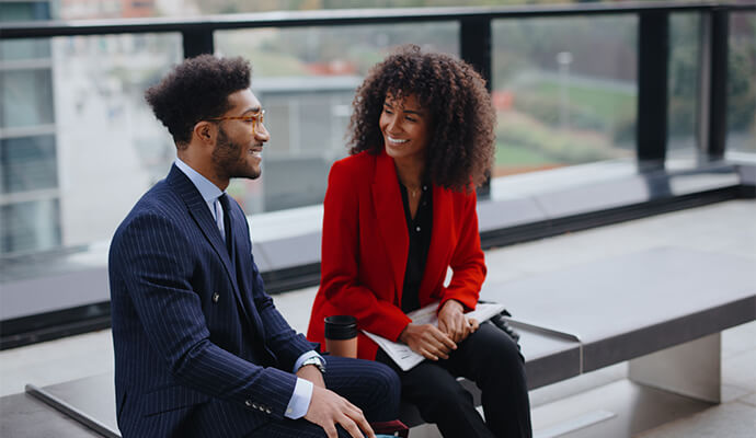 couple-in-office-attire-talking-business-ditrict-outdoors-bdo