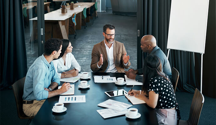 team-sitting-around-table-in-office-bdo