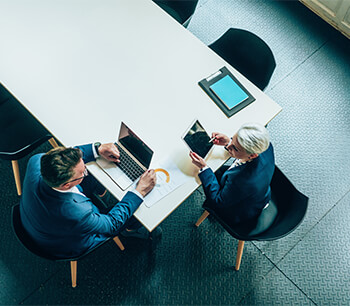 couple-working-on-devices-in-conference-room-bdo