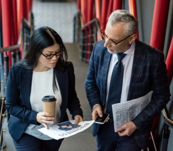 couple-discussing-news-holding-newspaper-bdo