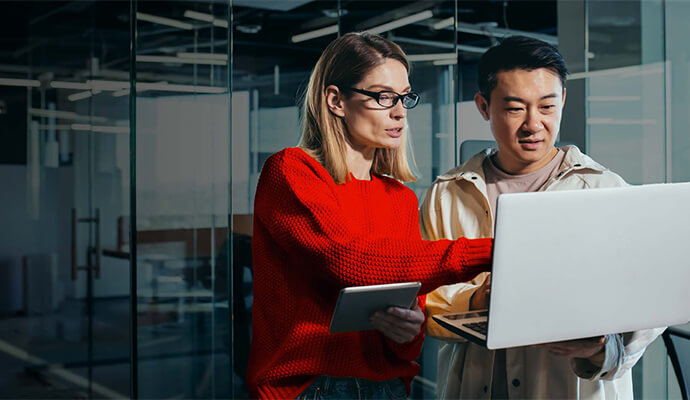 couple-working-on-laptop-standing-office-setting-bdo