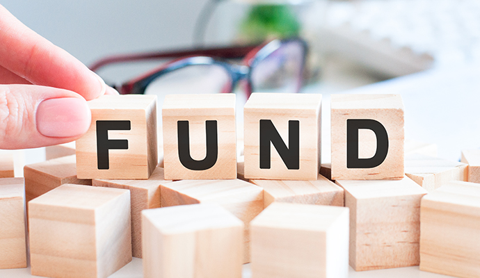 close-up-piggy-bank-with-man-using-laptop-background