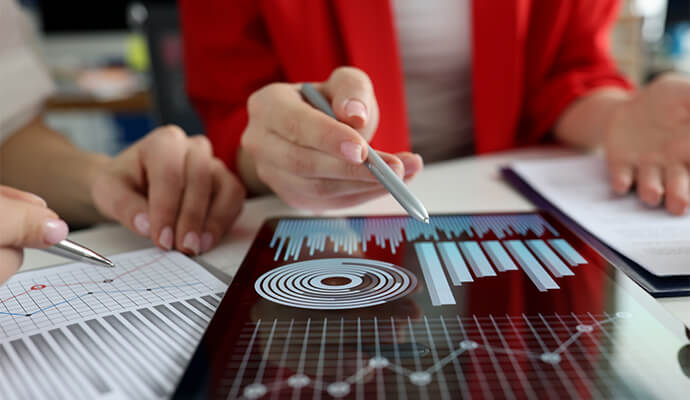 women-hands-over-screens-and-paperwork-showing-stats-bdo