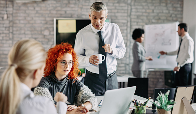 young-businesswoman-using-computer-with-colleagues