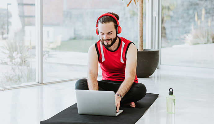 man-on-yoga-mat-wearing-headset-bdo