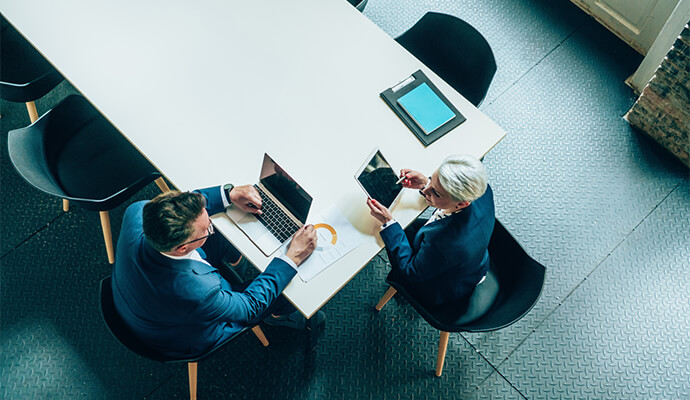 couple-working-on-devices-in-conference-room-bdo