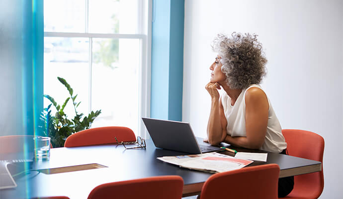 woman-looking-at-window-at-her-desk-bdo