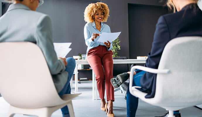 woman-holding-documents-smiling-at-audience-bdo