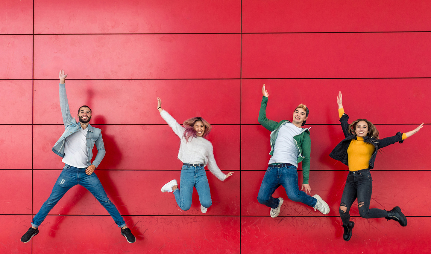 young-people-jumping-against-red-background-wall