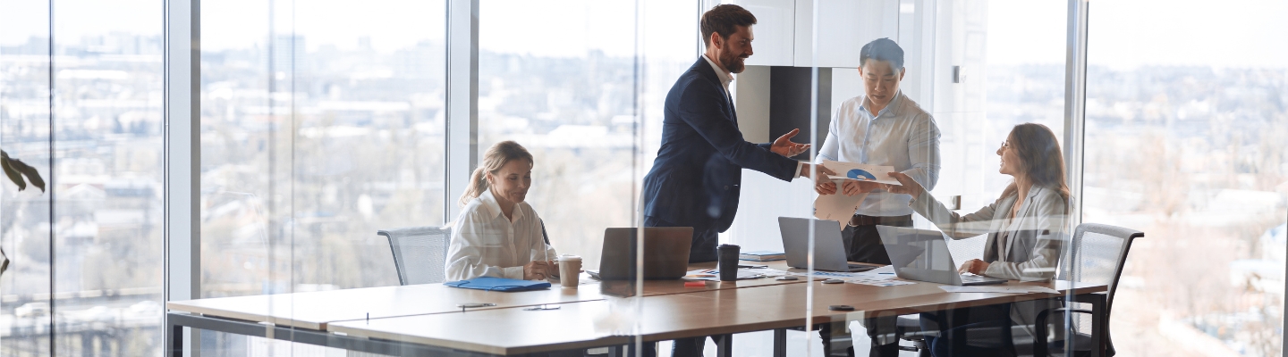 People-standing-near-table-team-working-and-communicating-together-in-office-