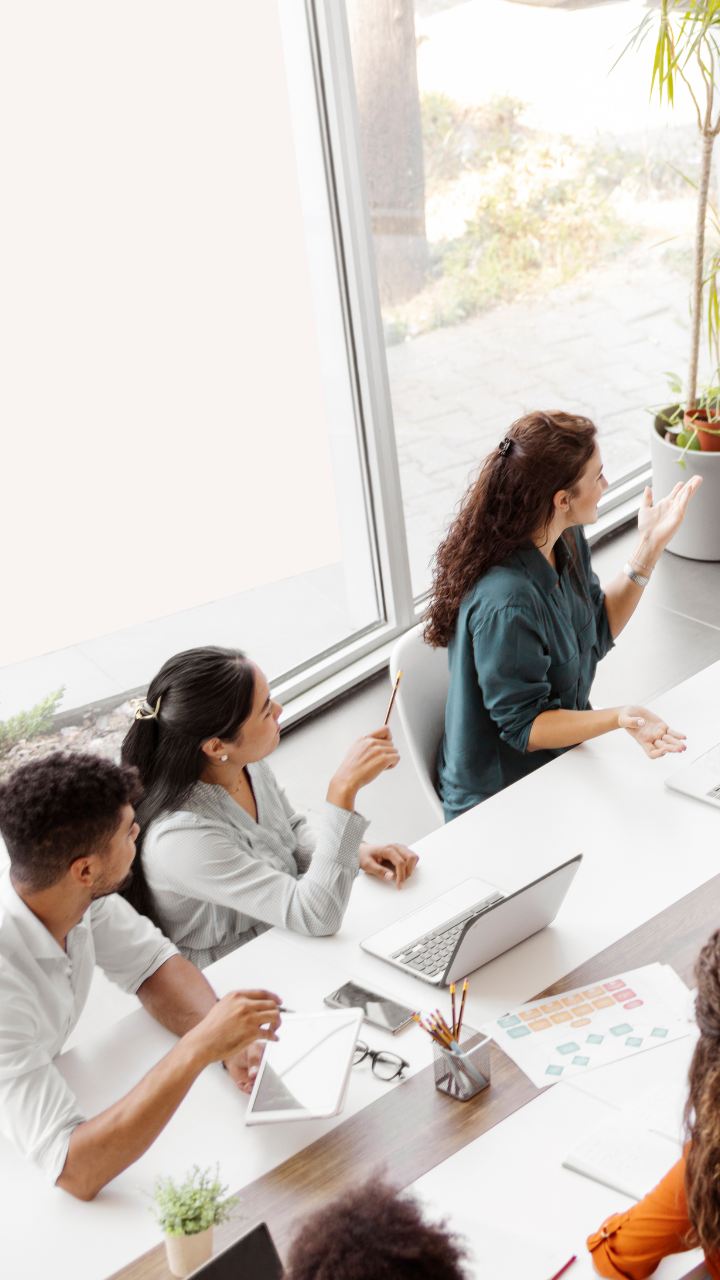 people-sitting-at-table-in-corporate-office-with laptops-